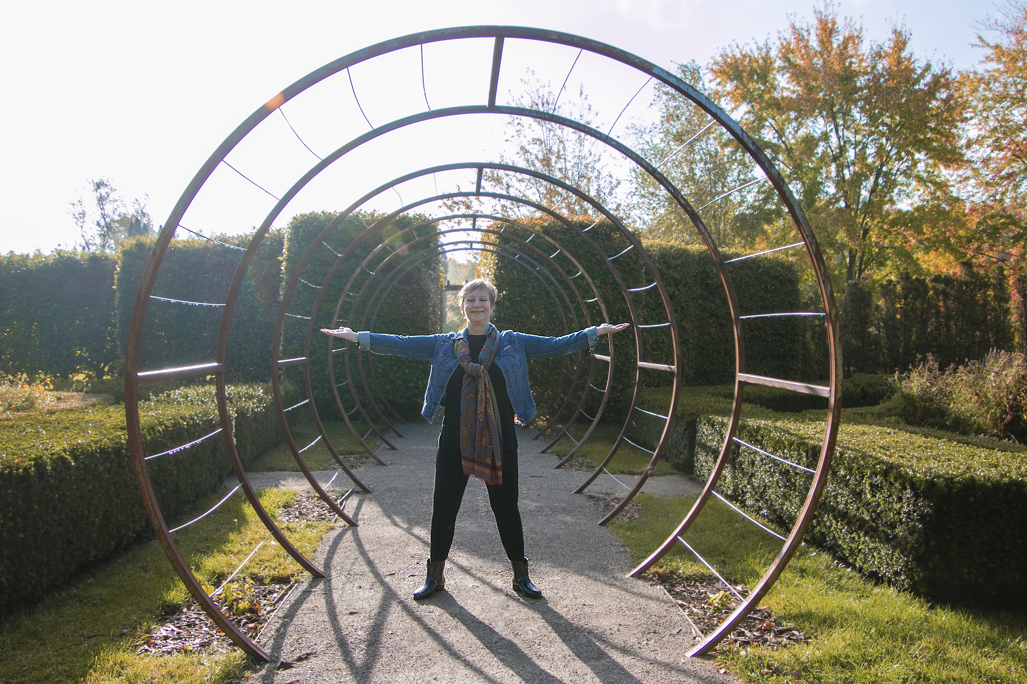 Heather Skoll in the Garden with arms out her sides. Is Knee Surgery right for you?